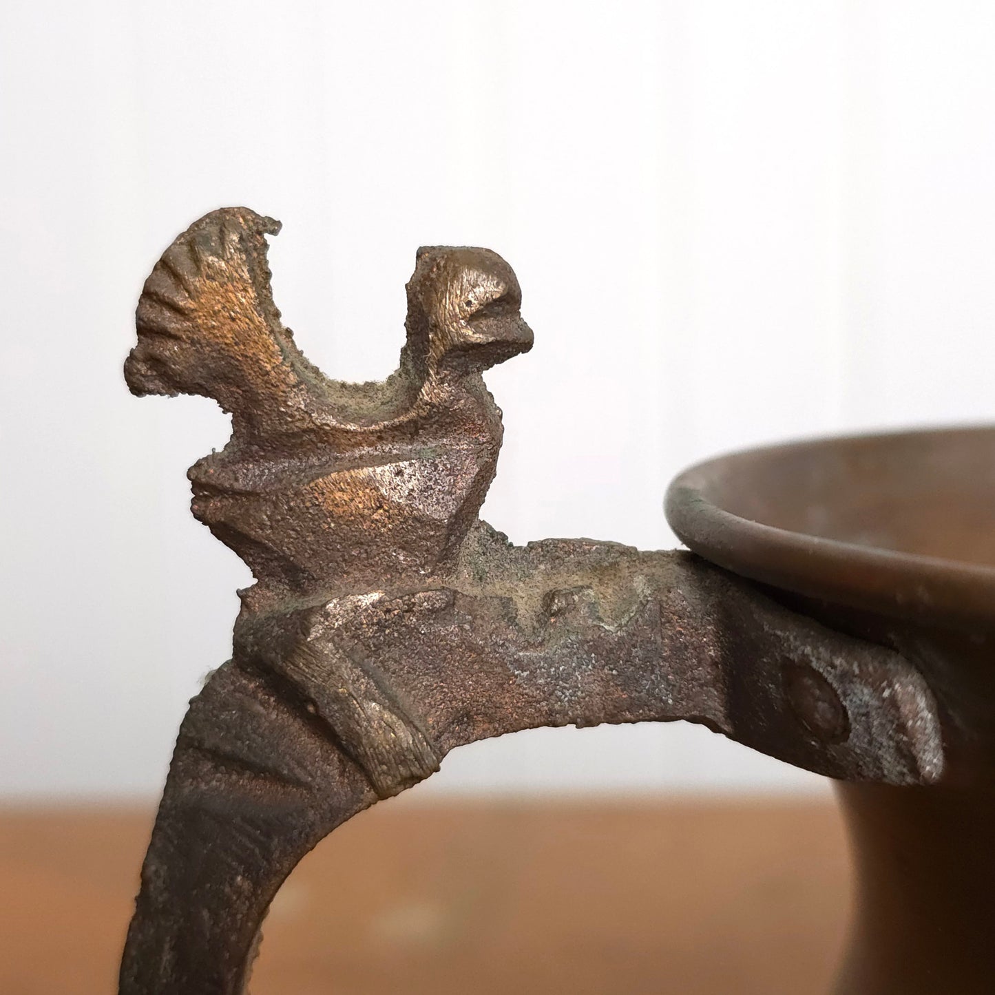 Detail of copper pitcher with brutalist bird handle